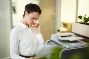 a lady is standing in front of stopped printer