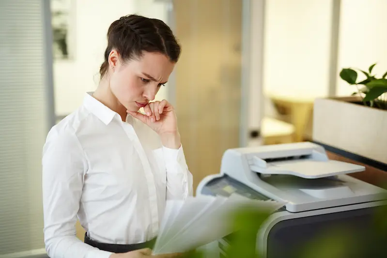 a lady is standing in front of stopped printer